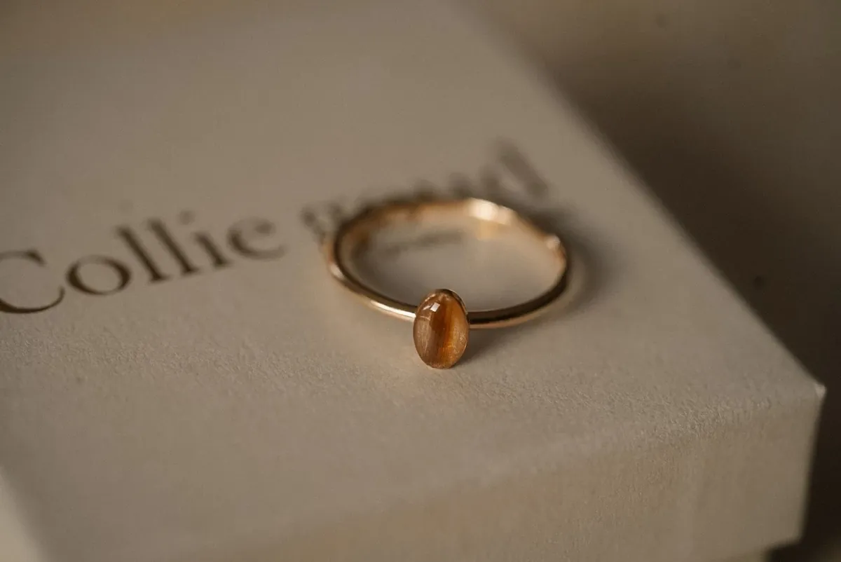 Gouden ring met een haarlok van Colliegoud op een sieradendoosje